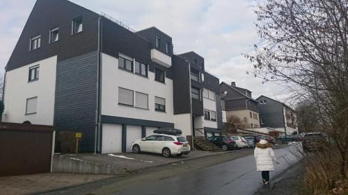 een vrouw die over een stoep loopt voor een gebouw bij Ferienwohnung Charlotte in Winterberg
