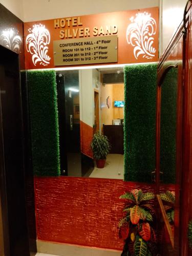 a lobby with green walls and a hotel silver sand sign at Hotel Silver Sand in Trivandrum