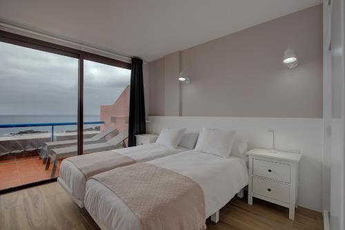 Un dormitorio con una cama con vista al mar. en Sonia´s Beach, en Los Cancajos