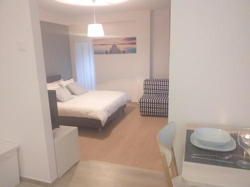 a small room with a bed and a table and a kitchen at Apartments Doris in Nova Vas