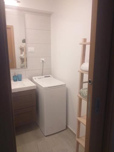 ein kleines Bad mit einem Waschbecken und einer Waschmaschine in der Unterkunft Apartments Doris in Nova Vas
