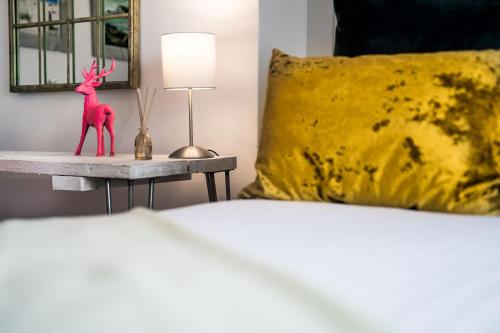 a bed with a red statue of a deer on a table at The Old Store Guest House in Chichester
