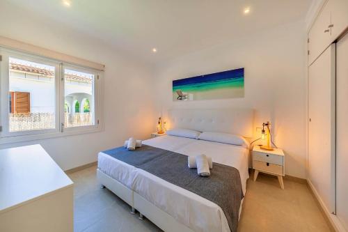 Un dormitorio con una cama grande y una ventana en villa amfora, en Puerto de Alcudia