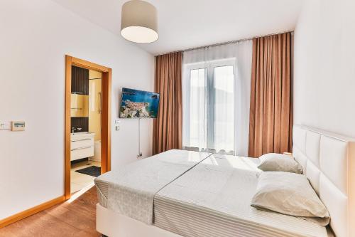 a bedroom with a large white bed and a window at Lux Panorama in Budva