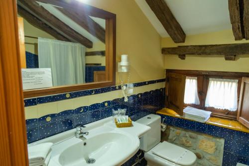 a bathroom with a sink and a toilet and a mirror at La Casona de Hermosa in Hermosa