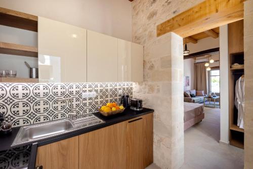 a kitchen with a sink and a bowl of oranges on the counter at CASA GIORGIO EXCLUSIVE SUITES in Rethymno