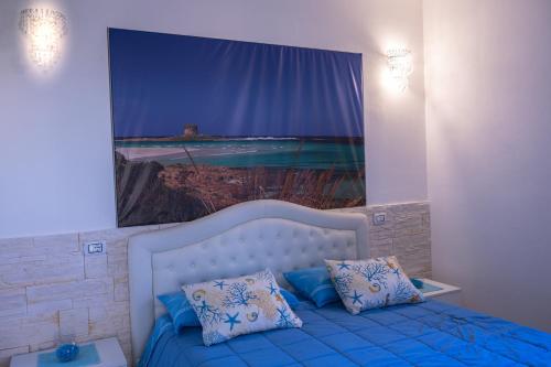 una camera da letto con un letto e un grande dipinto sul muro di Appartamento La Pelosa a Stintino