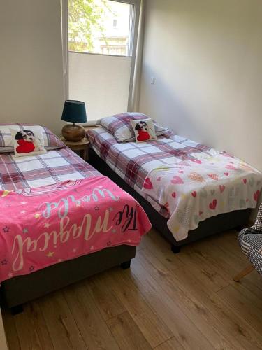 a bedroom with two beds and a window at Pod Beczką in Augustów