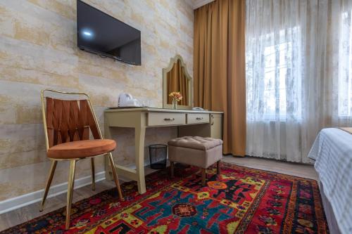 a hotel room with a desk and a television on a wall at NAR BOUTIQUE HOTEL in Baku