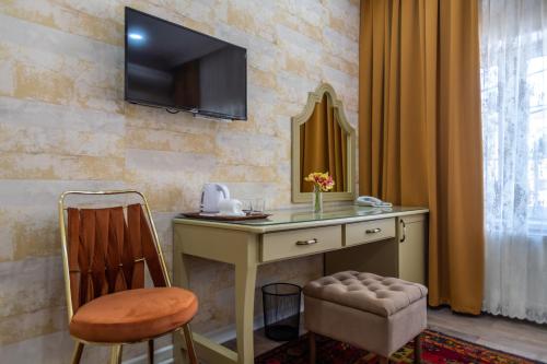 a desk with a chair and a television on a wall at NAR BOUTIQUE HOTEL in Baku