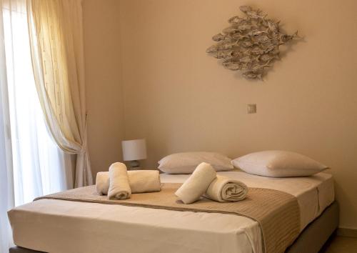 a bedroom with a bed with towels on it at Grand Bleu Apartments & Villas in Ermioni