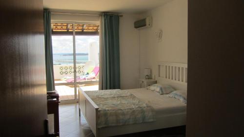 フェラグドにあるCasa Bele Algarveのベッドがあり海が見える寝室