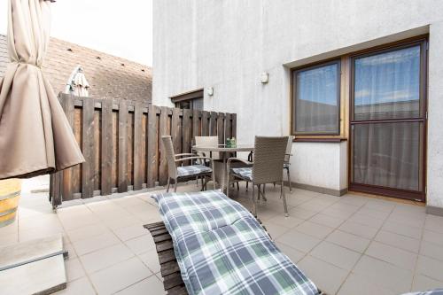 a patio with a table and chairs on a balcony at Weingut-Ferienwohnung Münzenrieder in Apetlon