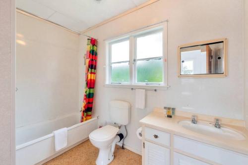 a bathroom with a toilet and a sink and a window at Little Self-Contained 1BR w Netflix - Parking in Auckland