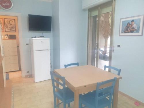 eine Küche mit einem Tisch und Stühlen sowie einem Kühlschrank in der Unterkunft Casa Centurione Silvi Marina in Silvi Marina