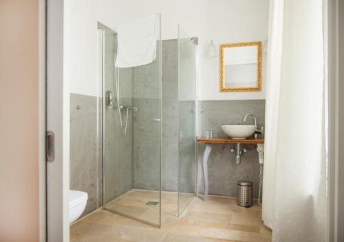uma casa de banho com uma cabina de duche em vidro e um lavatório. em Naturschlosshotel Blumenthal em Aichach