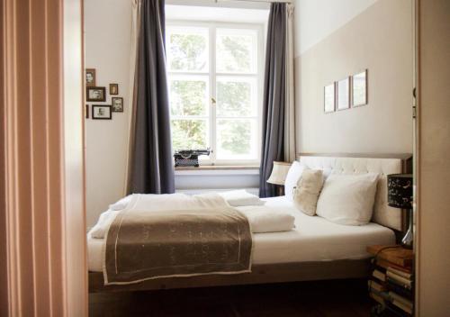 a bedroom with a bed with a window at Naturschlosshotel Blumenthal in Aichach