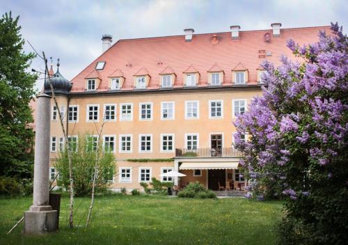 a large brick building with a red roof at Naturschlosshotel Blumenthal in Aichach