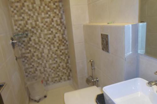 a bathroom with a shower with a toilet and a sink at Hotel Saffron Inn in New Delhi
