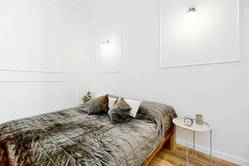 a bedroom with a bed and a white wall at Niron Apartament Dom z Papieru Sztokholm in Piła