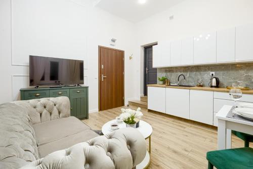 een woonkamer met een bank en een keuken bij Niron Apartament Dom z Papieru Sztokholm in Piła