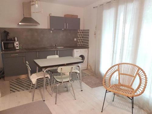 une cuisine avec une table et des chaises dans une pièce dans l'établissement vintage home, à LʼIsle-sur-la-Sorgue
