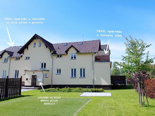 a white house with a black roof at Brunetti Apartmány Jeseníky in Karlovice