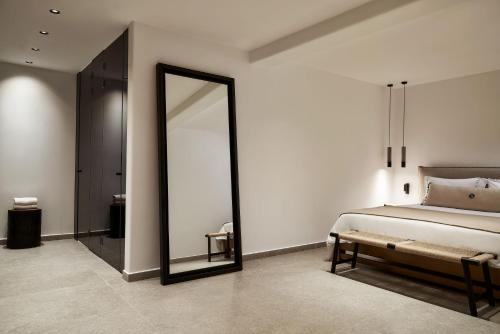 a bedroom with a large mirror and a bed at SantAnna Luxury Suites in Imerovigli