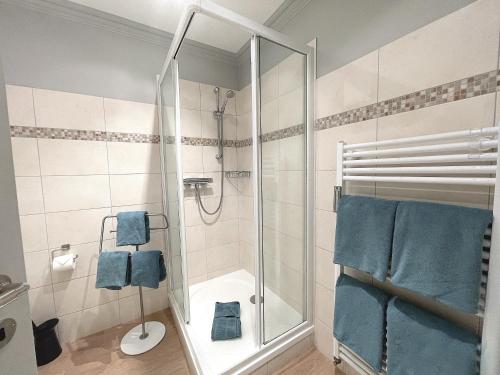 y baño con ducha y toallas azules. en Haus Stübbe beim Dorfteich, en Wenningstedt