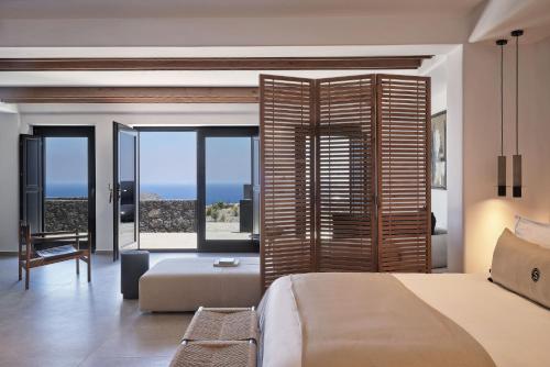 a bedroom with a bed and a view of the ocean at SantAnna Luxury Suites in Imerovigli