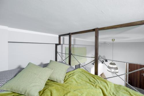 een slaapkamer met een bed met groene lakens en een spiegel bij Niron Apartament Dom z Papieru Nairobi in Piła