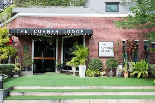 a building with a sign that reads the corner lodge at The Corner Lodge in Pattaya