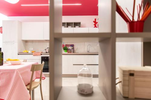 a kitchen with white cabinets and a table with a bottle at Fruttadamare in Porto Recanati