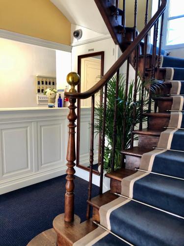 a spiral staircase in a home with blue carpet at Château Hôtel Edward 1er in Monpazier