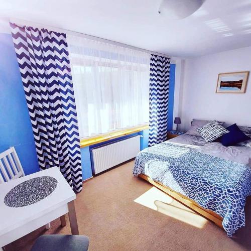 a bedroom with a bed and a table and a window at Pokoje gościnne "Trudziń-SKI" in Świeradów-Zdrój