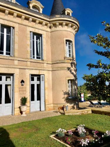 a building with a dog sitting in front of it at Château Hôtel Edward 1er in Monpazier