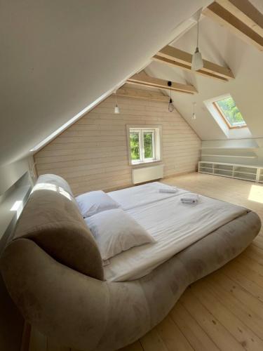 a bedroom with a large bed in the attic at Domki&Apartamenty Koszarka in Gródek Nad Dunajcem