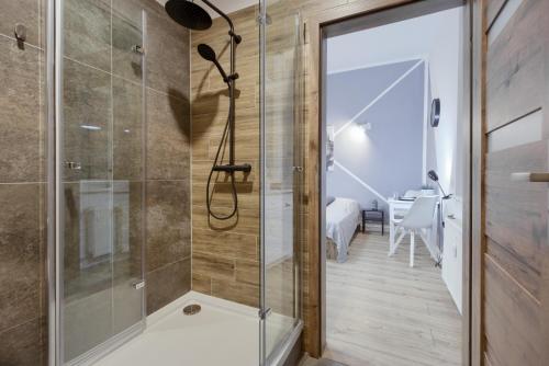 a glass shower in a bathroom with a bedroom at Niron Apartament Dom z Papieru Tokio in Piła