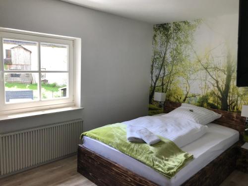 een slaapkamer met een bed en een groot raam bij Landgasthof Zum Dorfkrug in Schöneberg