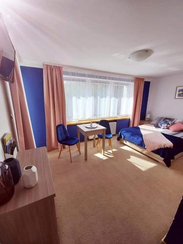 a bedroom with a bed and a desk and a table at Pokoje gościnne "Trudziń-SKI" in Świeradów-Zdrój