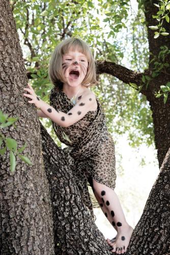 a little girl sitting in a tree at Madikwe Hills Private Game Lodge in Madikwe Game Reserve
