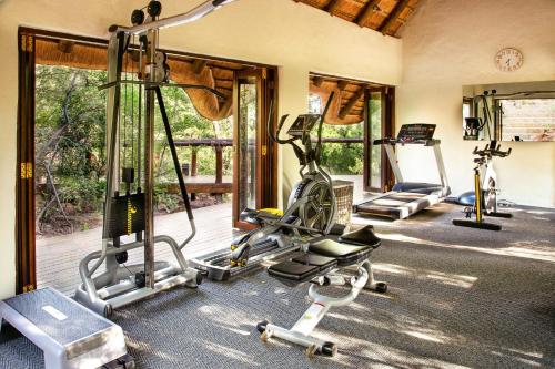 un gimnasio con varias cintas de correr y bicicletas en una habitación en Madikwe Hills Private Game Lodge, en Reserva de Madikwe