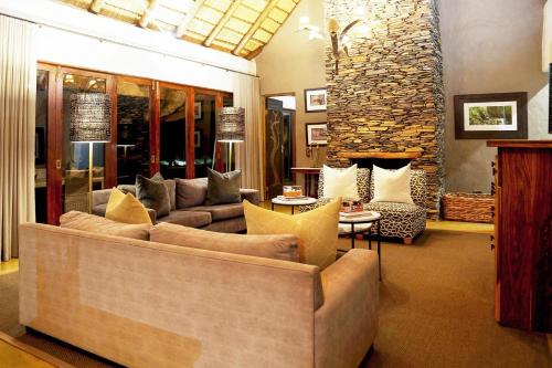 a living room with a couch and a fireplace at Madikwe Hills Private Game Lodge in Madikwe Game Reserve