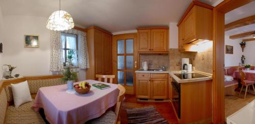 eine Küche und ein Wohnzimmer mit einem Tisch und einem Waschbecken in der Unterkunft Haus Waidmannsglück in Bischofswiesen
