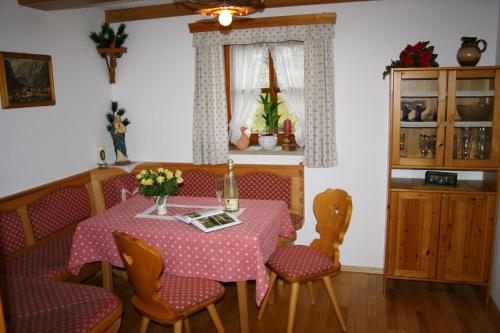 ein Esszimmer mit einem Tisch, Stühlen und einem Fenster in der Unterkunft Haus Waidmannsglück in Bischofswiesen