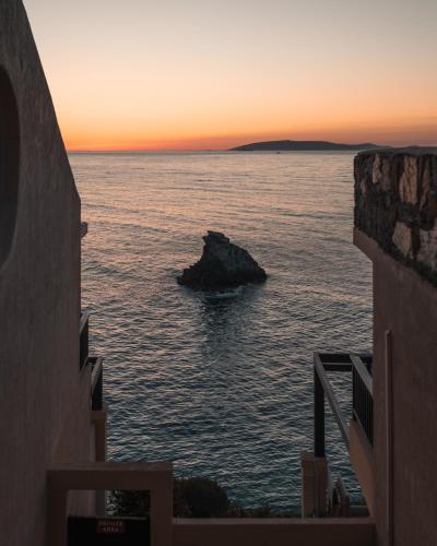 a view of the ocean at sunset from between two buildings at Seaside A Lifestyle Resort - Adults Only in Agia Pelagia