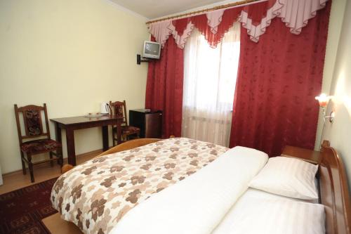 a bedroom with a bed and a window with red curtains at Hotel Star in Stryi