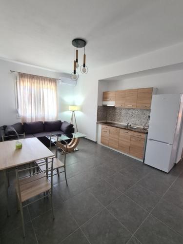 een keuken en een woonkamer met een tafel en een koelkast bij Seaside Apartments in Keramotí