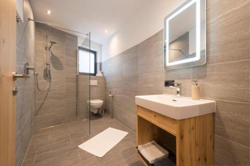 W łazience znajduje się umywalka i prysznic. w obiekcie Arlalps Apart w mieście Pettneu am Arlberg