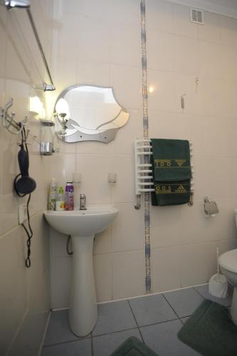 a white bathroom with a sink and a mirror at Hotel Star in Stryi